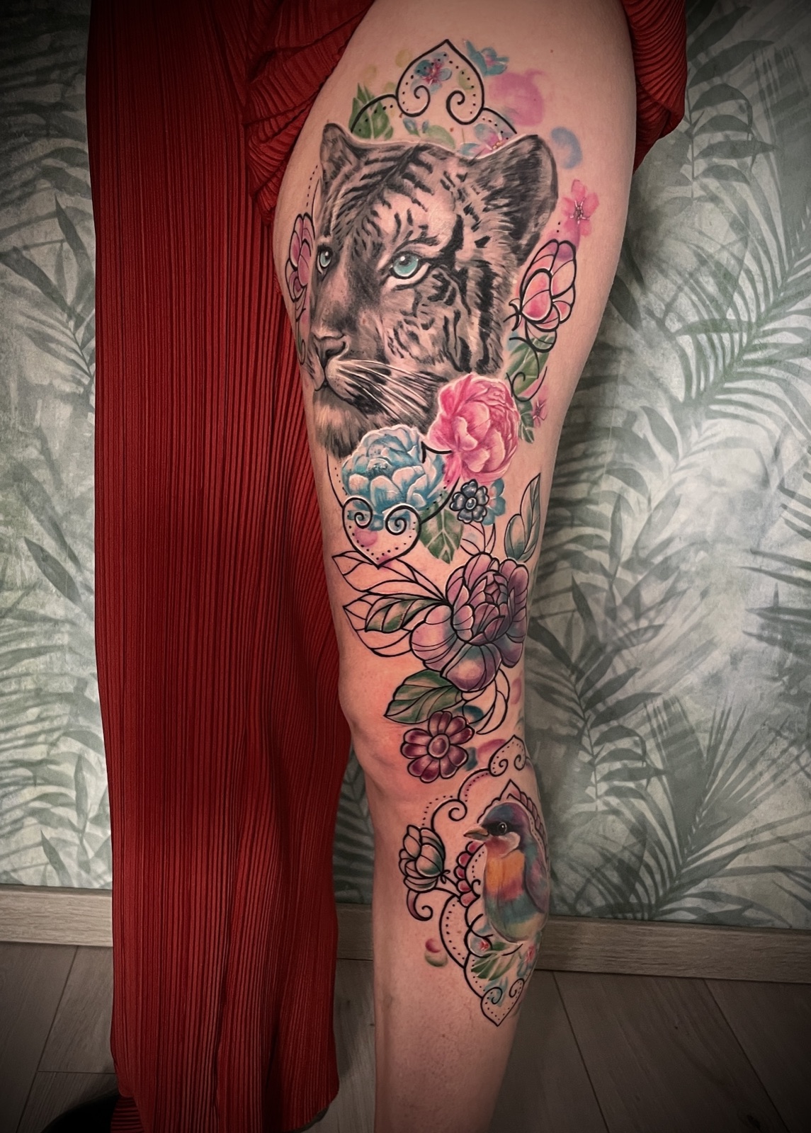 Leopard mit Blumen am Bein — buntes Tattoo von Pia Insel